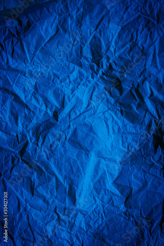 Rough navy blue paper texture. Blue crumpled paper texture and background. Close up view of wrinkled navy blue texture.