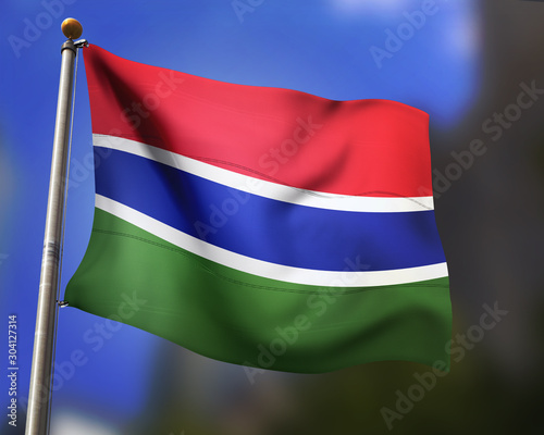 Gambian flag waving in blue sky photo