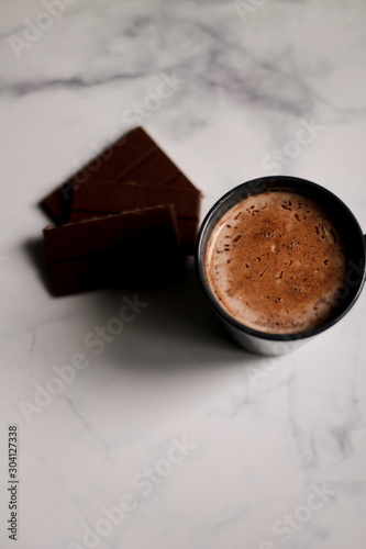 cocoa drink in a blue mug with chocolate on a light background closeup