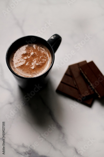 cocoa drink in a blue mug with chocolate on a light background closeup