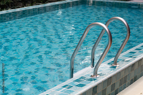 Ladder stainless handrails in private luxury swimming pool © Art789