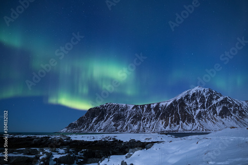 Fototapeta Naklejka Na Ścianę i Meble -  Beautiful northern lights over the snow covered winter landscape of the Lofoten islands