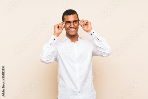 Young handsome brunette man over isolated background with glasses and surprised © luismolinero