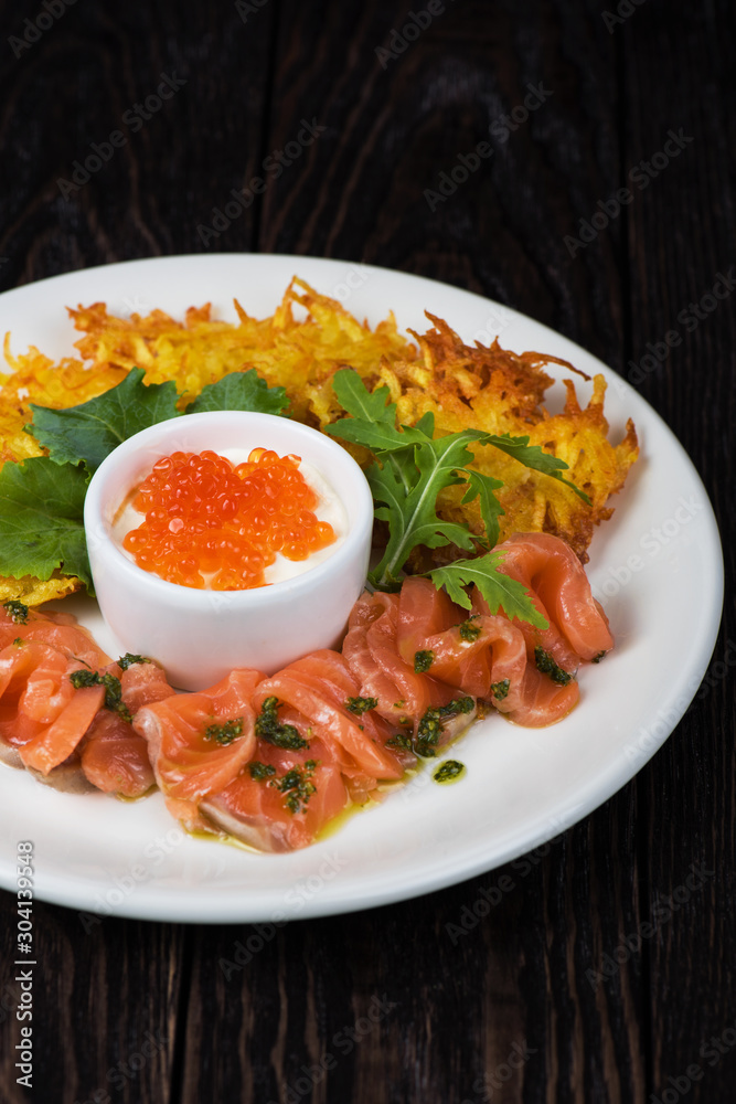 Plate with potato pancakes salmon fish and red caviar Plate with potato pancakes salmon fish and red caviar