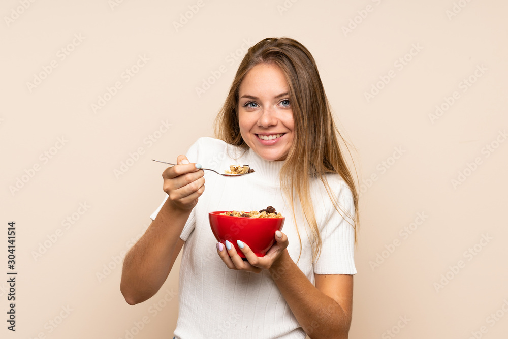 Young blonde woman over isolated background holding a bowl of cereals Young blonde woman over isolated background holding a bowl of cereals