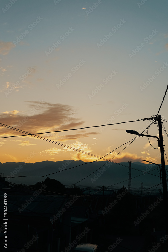 dusk in the golden hour with the foreground of a series of electrical cables