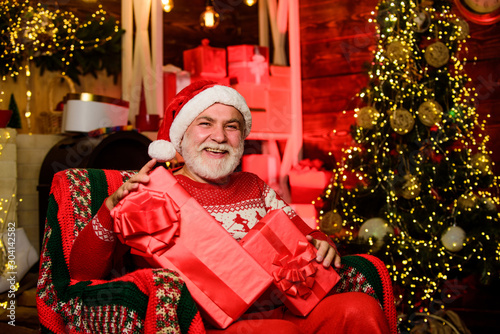 Traditions concept. Legend about Santa Claus. Bearded senior man Santa Claus. Merry christmas. Elderly grandpa at home. Delivering gifts. Presents for family. Santa Claus relaxing in arm chair