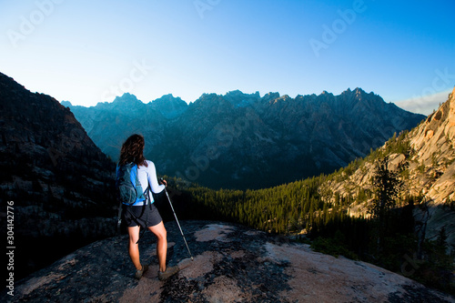 A woman enjoys the dramatic view of a of the Sawtooth Mountains near the Elephant's Perch, a popular climbing destination by the beautiful Saddleback Lakes. The whole area is so stunning it has earned the nickname 'Shangrila. photo