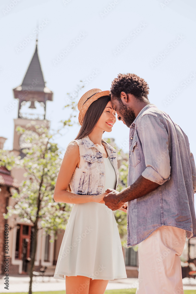 portrait of asian woman and african american man holding hands on the street at daytime
