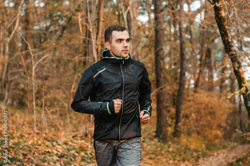 Concept of sport and active lifestyle. A young man is Jogging in the autumn Park