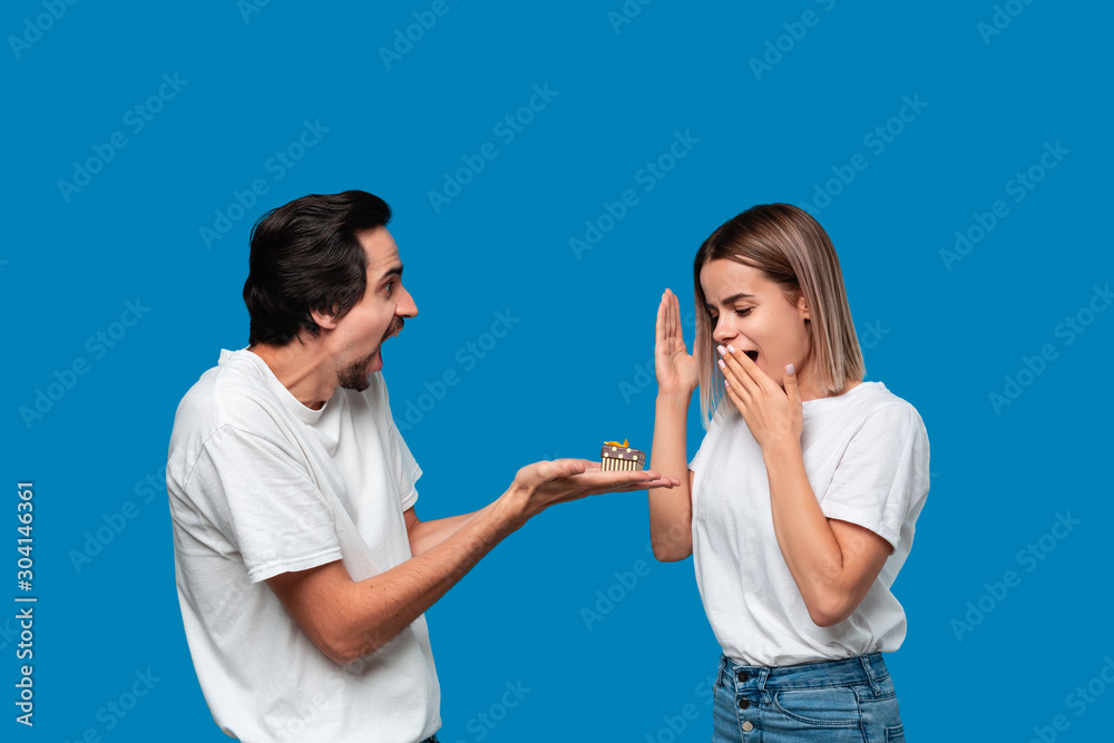 Boyfriend giving present to his girlfriend isolated over blue background. Boyfriend giving present to his girlfriend isolated over blue background.
