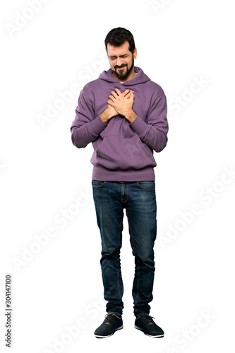 Full-length shot of Handsome man with sweatshirt having a pain in the heart over isolated white background © luismolinero