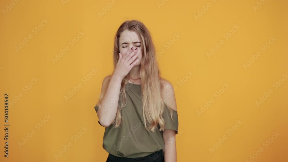 Gorgeous young caucasian girl making sleep gesture in dorable expression wearing pretty haki shirt on isolated yellow background Gorgeous young caucasian girl making sleep gesture in dorable expression wearing pretty haki shirt on isolated yellow background