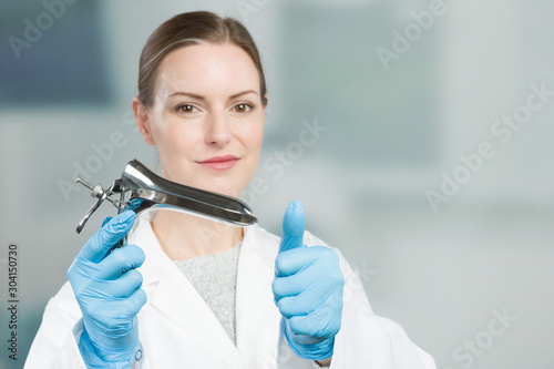 Female gynecologist with a speculum in her hand photo