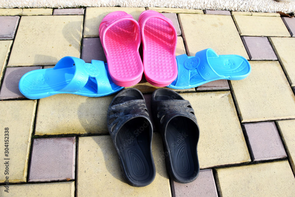 On the tile are three pairs of slates, slippers, two adults and one for  children. Stock Photo | Adobe Stock