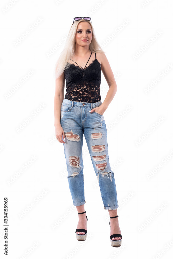 Young beautiful casual blonde woman with sunglasses on head and hand in pocket looking away interested. Full body isolated on white background. Young beautiful casual blonde woman with sunglasses on head and hand in pocket looking away interested. Full body isolated on white background.