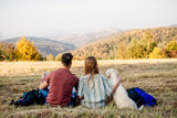 Happy couple sitting together outdoors during hiking travel