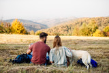 Happy couple sitting together outdoors during hiking travel
