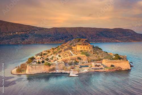 View of the island of Spinalonga with calm sea. Here were isolated lepers, humans with the Hansen's desease, gulf of Elounda, Crete, Greece.  photo