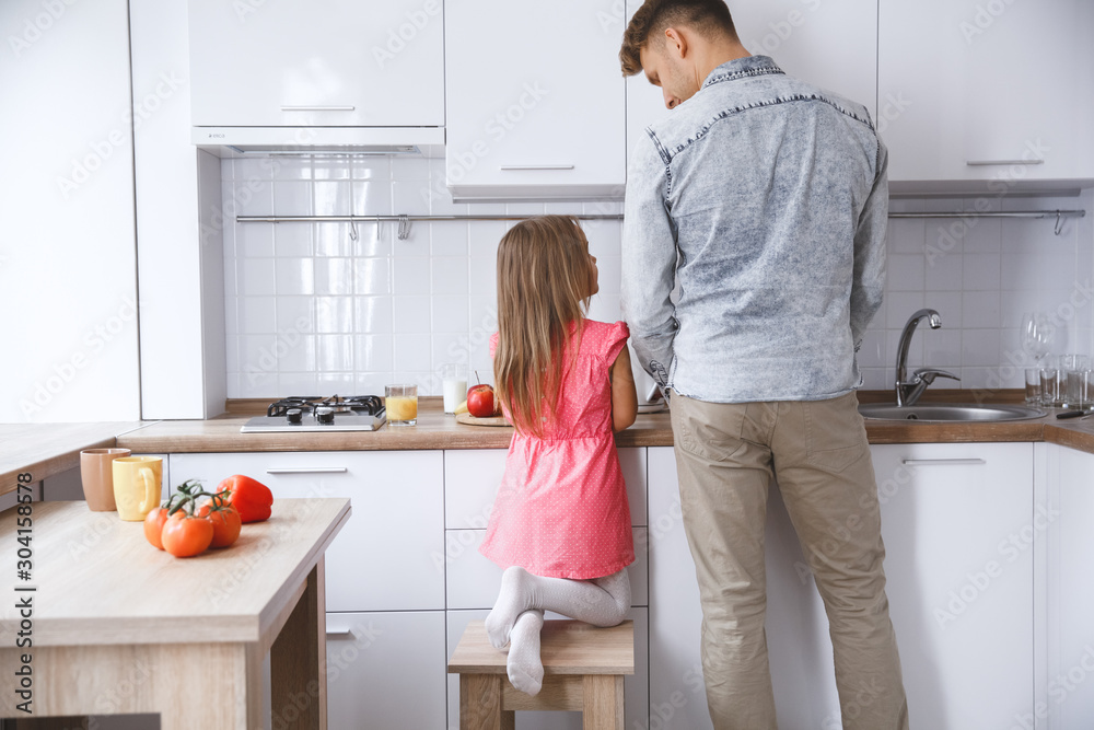 Little kid girl with father at home childhood concept cooking breakfast