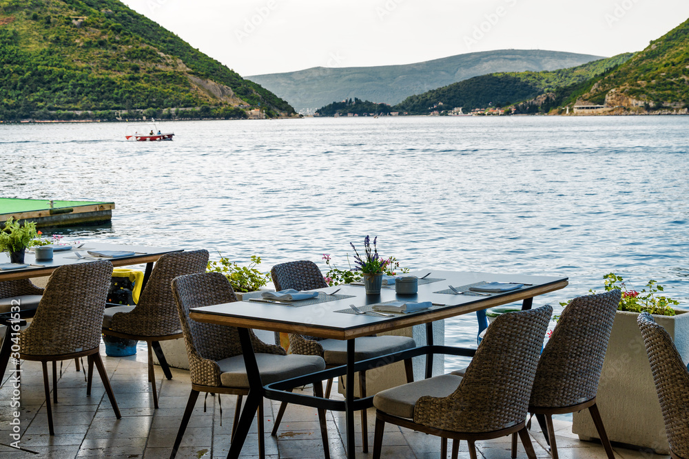 Sunny view of coastal cafe with beautiful view of Kotor Bay, Perast, Montenegro.