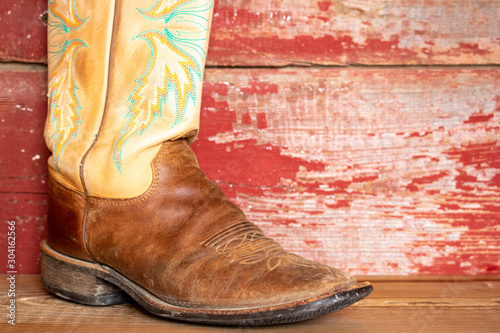 Cowboy boots on red barn board