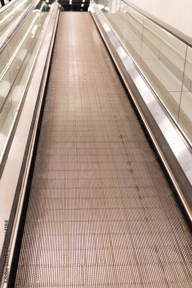 View of the travolators from the bottom up in the shopping center. A stepless escalator facilitates the movement of people from the first floor to the top View of the travolators from the bottom up in the shopping center. A stepless escalator facilitates the movement of people from the first floor to the top