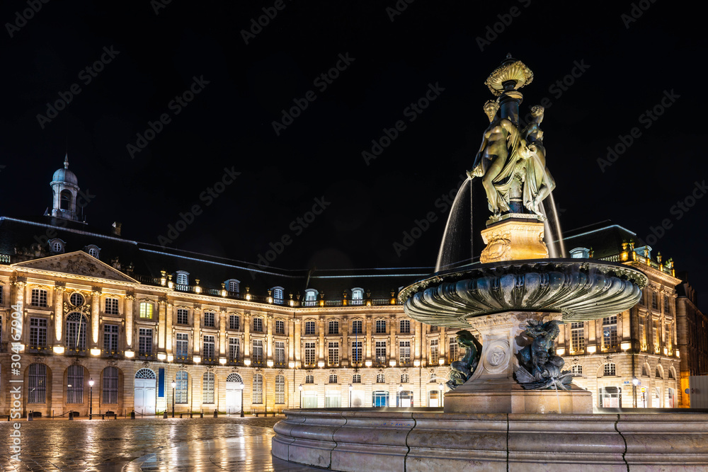 Obraz premium Fountain of three graces on the place de la bourse in Bordeaux at night in Gironde, New Aquitaine, France