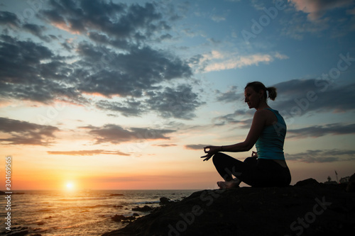 Silhouette of yoga woman on the sea during amazing sunset. © De Visu