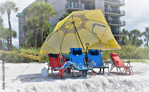 Yellow Beach Umbrella and colorful beach chairs in a Florida message convery the message the beach life is fun and good photo