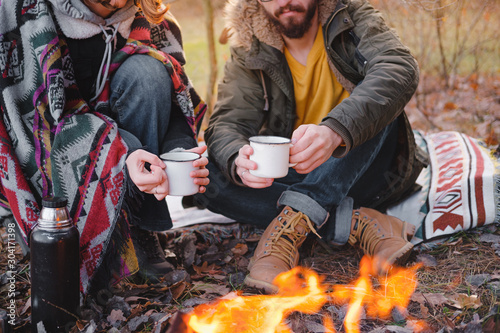 Two people having a lovely time outdoors in autumn. Man and woman in warm clothes sit outdoors together on a lovely chilly day #304171398