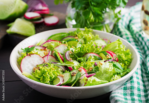 Healthy vegan food. Vegetarian vegetable salad of radish, cucumbers, lettuce and red onion.