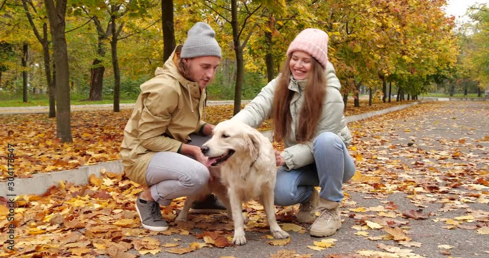 Young couple with cute dog in autumn park Young couple with cute dog in autumn park
