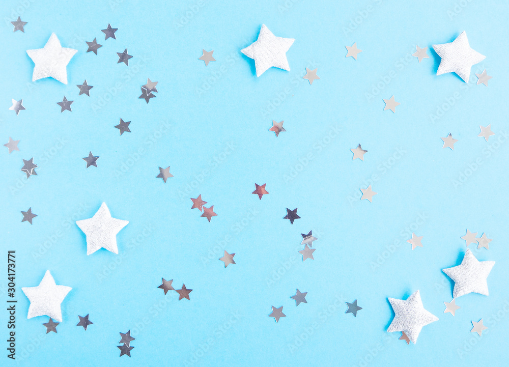 Fototapeta Christmas and New year composition with silver stars on blue background. Flat lay, top view, copy space.