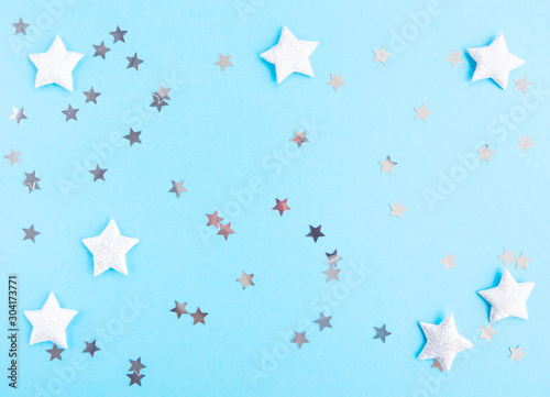 Christmas and New year composition with silver stars on blue background. Flat lay, top view, copy space. 