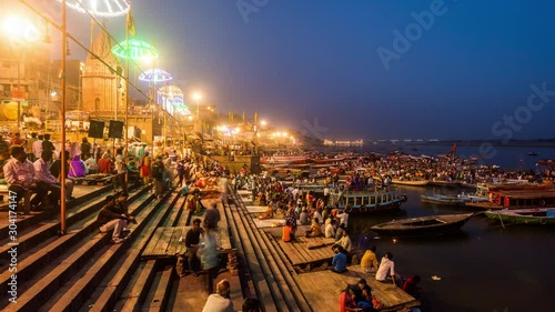 People watching hindu priests performing Agni Puja or Worship of Fire at a ghat in Varanasi day to night time lapse