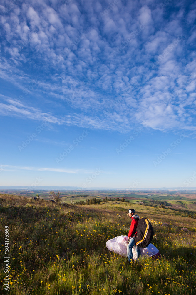 A man prepares his kite for flight on an early morning paragliding outing in north Idaho. A man prepares his kite for flight on an early morning paragliding outing in north Idaho.