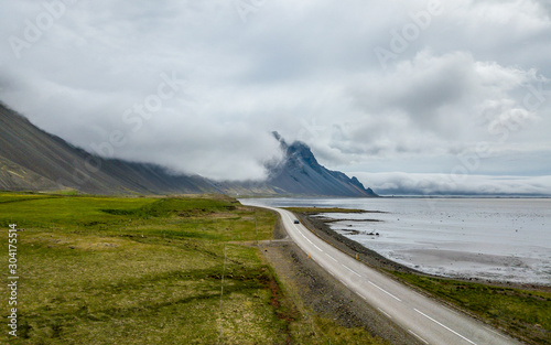 Droga na wybrzeżu, góry w chmurach, krajobraz Islandia