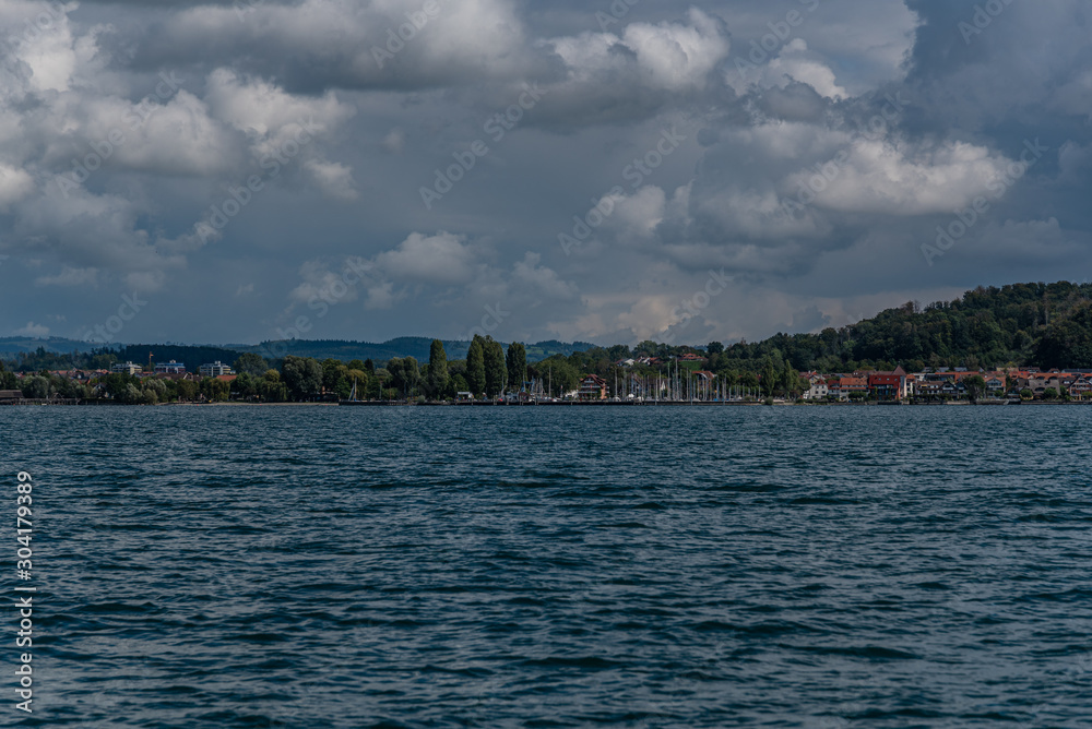 Naklejka premium The shoreline at lake constance with clouds in the background