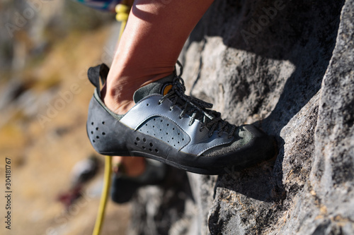 Detail shot of a woman's climbing shoe on rock.