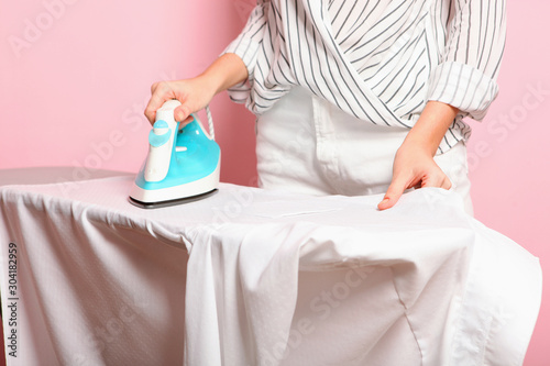 Fotografía Girl ironing clothes on an ironing board.