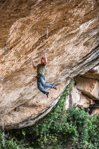 A man on Victimes del passat 8c (5.14b) at the Roca de Finestra wall near Maragalef, Spain. photo