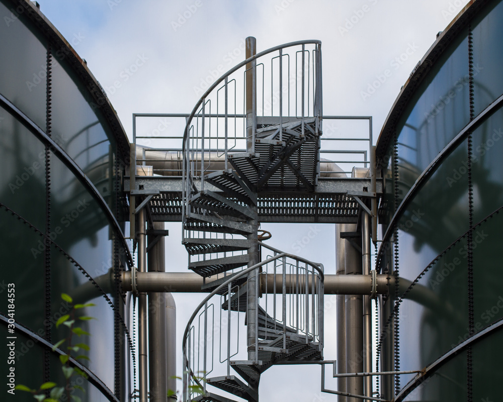 Naklejka premium industry: winding stairs between two gas storage tanks