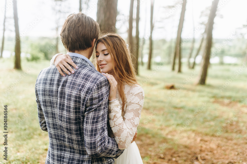 Fototapeta premium A young couple of brides walking in the pine forest