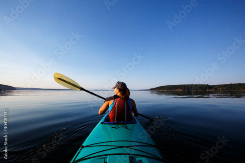 Rear view of woman kayaking in sea