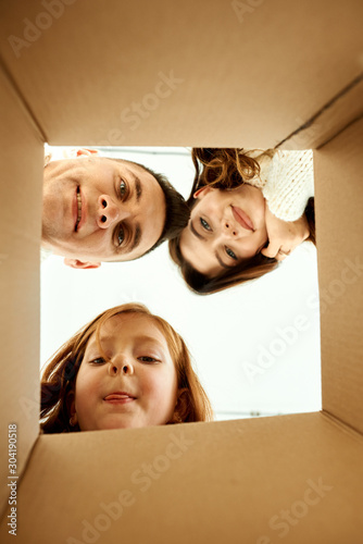 Family unpacking cardboard boxes at new home on a white background