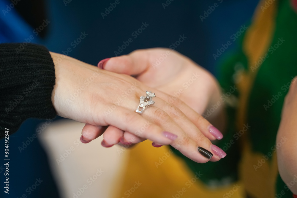 pretty girl gives her friend a present wedding ring on christmas. happy woman lovely couple.