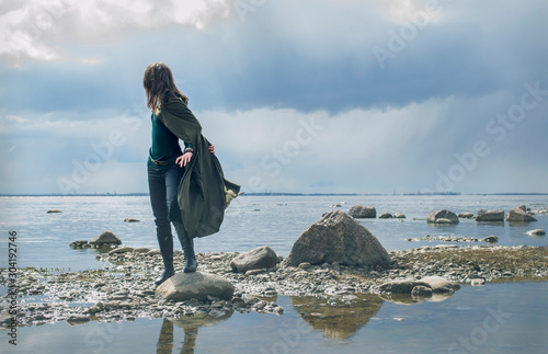 cosplay witch elf on the rocky shore by the sea
