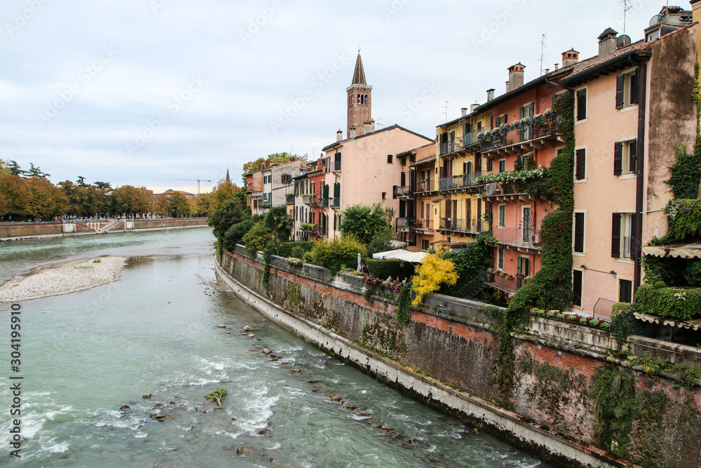The cityscape of the ancient town of Verona in Italy. You can see the river Adige and the houses by the riverside. 