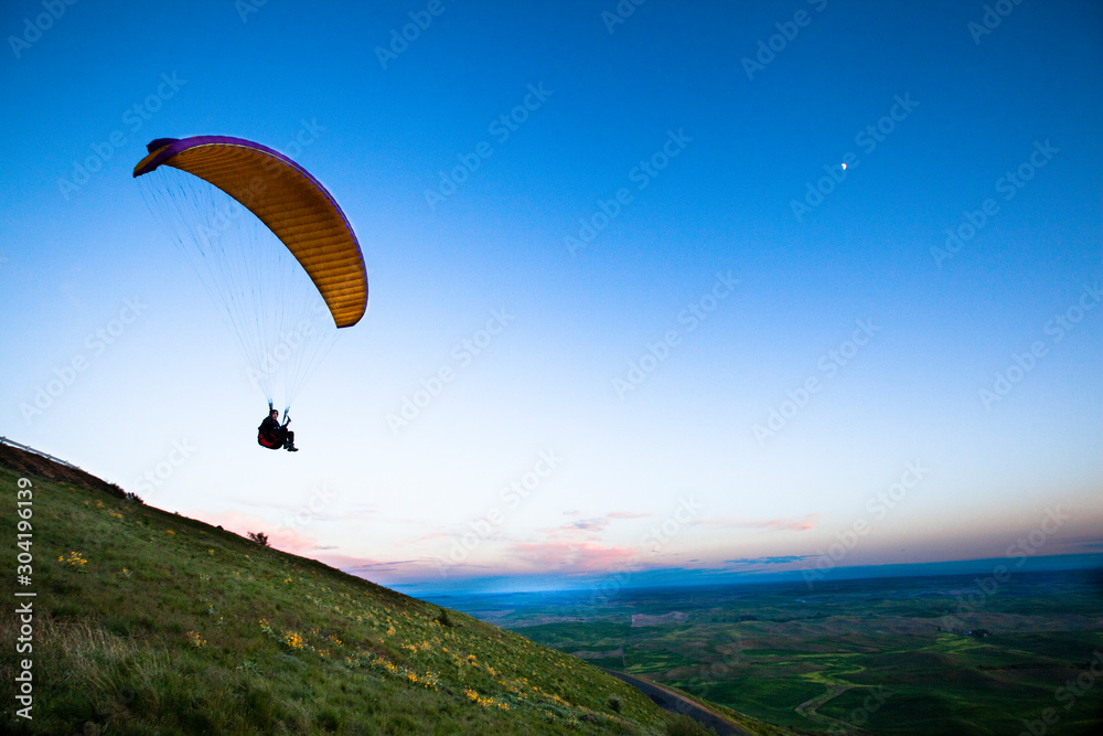 Darrell Anglen lifts off into the twilight while paragliding off Steptoe Butte in the Palouse at dusk. Darrell Anglen lifts off into the twilight while paragliding off Steptoe Butte in the Palouse at dusk.